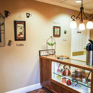 A cozy coffee station with warm lighting and decorative wall art.