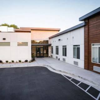 A modern commercial building with a clean driveway leading to the entrance.