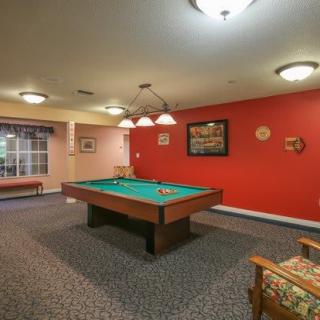 A cozy game room featuring a classic pool table, warmly lit and inviting for recreation.
