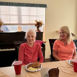 Two women enjoying a meal together in a cozy indoor setting.