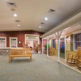 A cozy indoor seating area with benches and rocking chairs under soft lighting.
