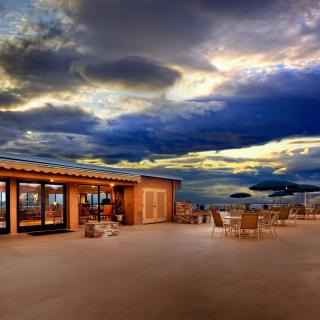 A picturesque outdoor restaurant patio at sunset with dramatic clouds in the sky.