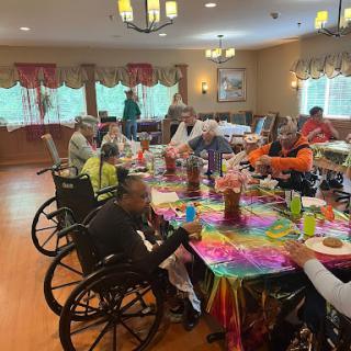 A lively community gathering at a retirement home, featuring residents enjoying a colorful meal together.