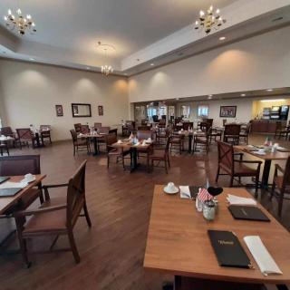 An empty restaurant dining area with neatly arranged tables and chairs.