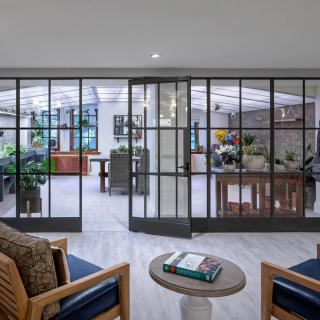 A modern living room with glass doors, comfortable seating, and stylish decor.