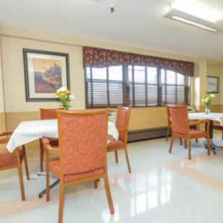 A well-lit dining area with tables and chairs, adorned with floral decorations.