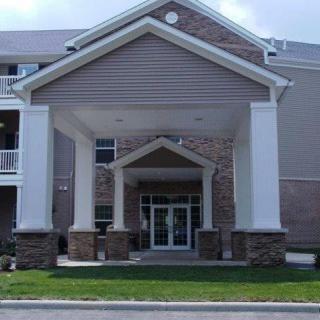 The image shows the entrance of a building with columns and a peaked roof.