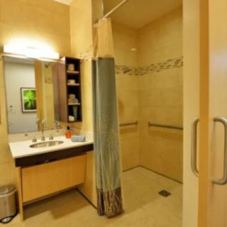 A modern bathroom with a sink, mirror, and shower area.