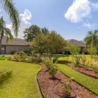 A well-maintained garden with lush greenery and colorful flower beds in a residential backyard.