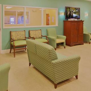 A cozy waiting room with comfortable seating and a television.