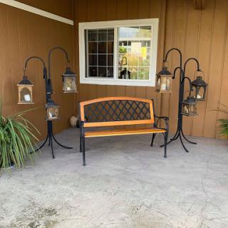 A cozy outdoor seating area with a decorative bench and lanterns.