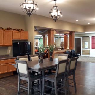 Modern kitchen and dining area with wooden cabinetry and stylish lighting.