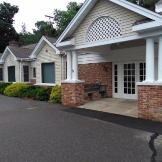 A welcoming entrance to a charming residential building, surrounded by greenery.