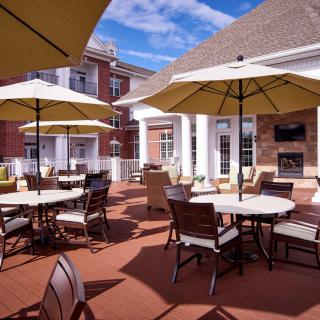 An inviting outdoor patio area with tables and chairs under large umbrellas.