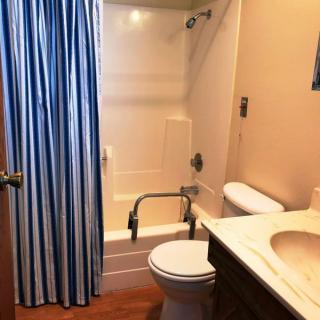 A small bathroom with a shower, toilet, and sink.