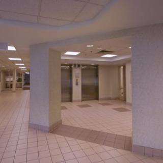 An empty lobby area with elevators and tiled flooring.