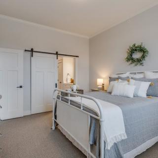 A cozy modern farmhouse bedroom with a stylish bed, barn door, and elegant decor.