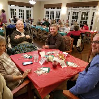 A warm gathering at a community dining event with friends enjoying their time together.