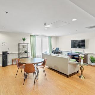 A modern living room with a sofa, television, and dining table.