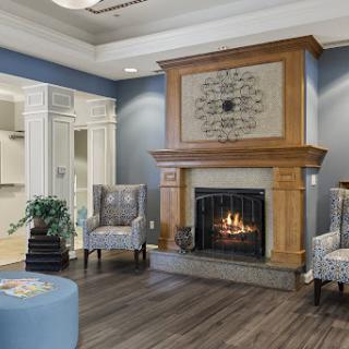 A cozy living room featuring a warm fireplace, stylish blue walls, and comfortable seating arrangements.