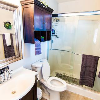 A modern bathroom with a sink, toilet, and glass-enclosed shower.