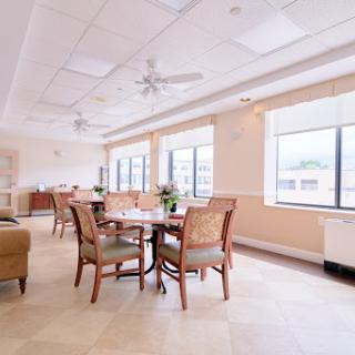 A bright and inviting dining area featuring comfortable furniture and large windows.