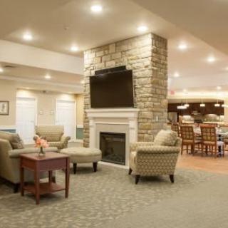 A cozy living room featuring a stone fireplace and seating area with comfortable furniture.