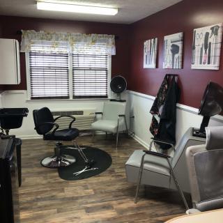 A cozy salon waiting area with multiple chairs and wall art.