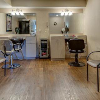 A cozy hair salon with styling stations, chairs, and large mirrors.