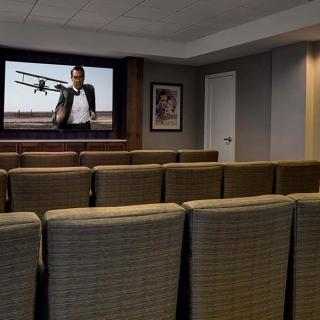 A cozy home theater room with comfortable seating and a large movie screen.