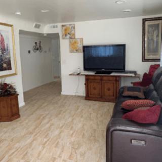 A cozy living room with a television, comfortable seating, and wall art.