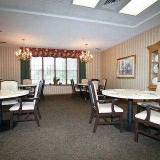 A well-lit dining room with elegant decor and multiple tables set for guests.