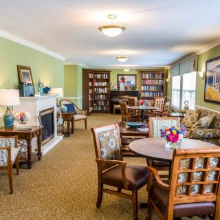 A cozy living room with bookshelves, a fireplace, and comfortable seating arrangements.