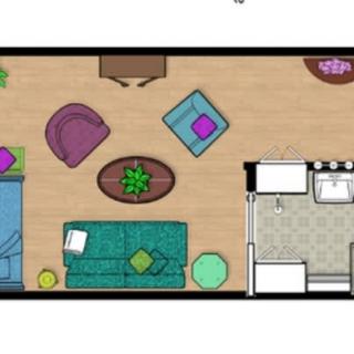 A color-coded floor plan showing a living room with various furniture pieces and a small kitchen area.