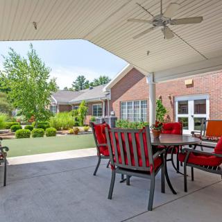 A cozy patio with outdoor seating and a view of the garden, perfect for relaxation.