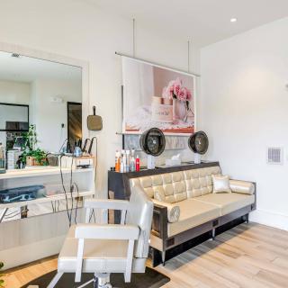 A modern living room with a stylish sofa and chair, featuring wood flooring and decorative elements.