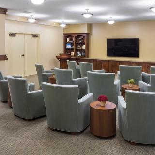 A well-arranged conference room featuring comfortable seating and a large television screen for presentations.