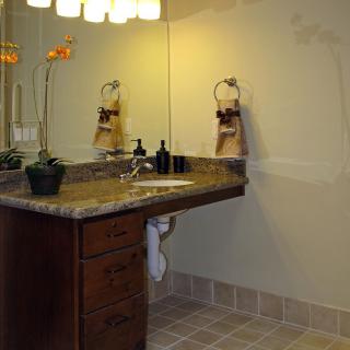 Modern bathroom with vanity, mirror, and elegant lighting.