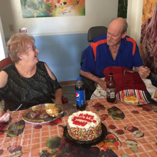 A joyful celebration with delicious food and cake shared between two friends.