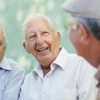 A group of elderly individuals enjoying a conversation outdoors.