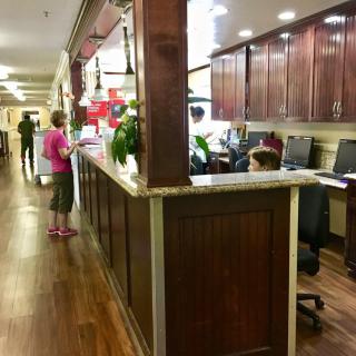 Reception area with people interacting and working at desks.