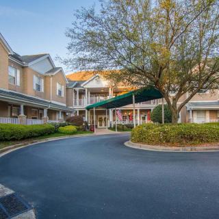 A residential building with a landscaped entrance and driveway.