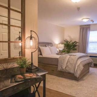 A cozy, modern bedroom with stylish decor and warm lighting.