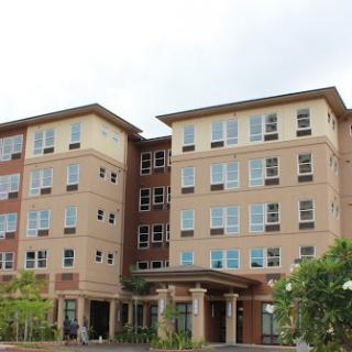 A modern multi-story residential building featuring large windows and a welcoming entrance.