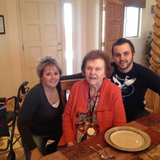 Three people gathered around a dining table, smiling for the photo.