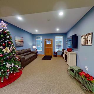 A cozy living room decorated for the holidays with a Christmas tree and comfortable seating.