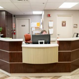 A reception area with a receptionist seated at the front desk.