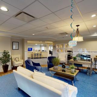 A modern office interior featuring a lounge area with comfortable seating, decor, and plants.