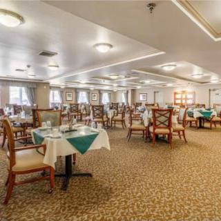 An elegant dining room with neatly arranged tables and chairs, set for a meal.