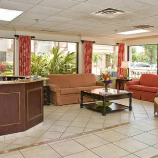 A hotel lobby featuring a reception desk and seating area with sofas and tables.